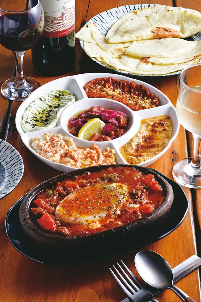ディップ状の彩り豊かなメゼを自家製のトルコのパン、エキメキと。店内で挽いたラム挽き肉と野菜のトマト煮込みにはとろりと卵がのる