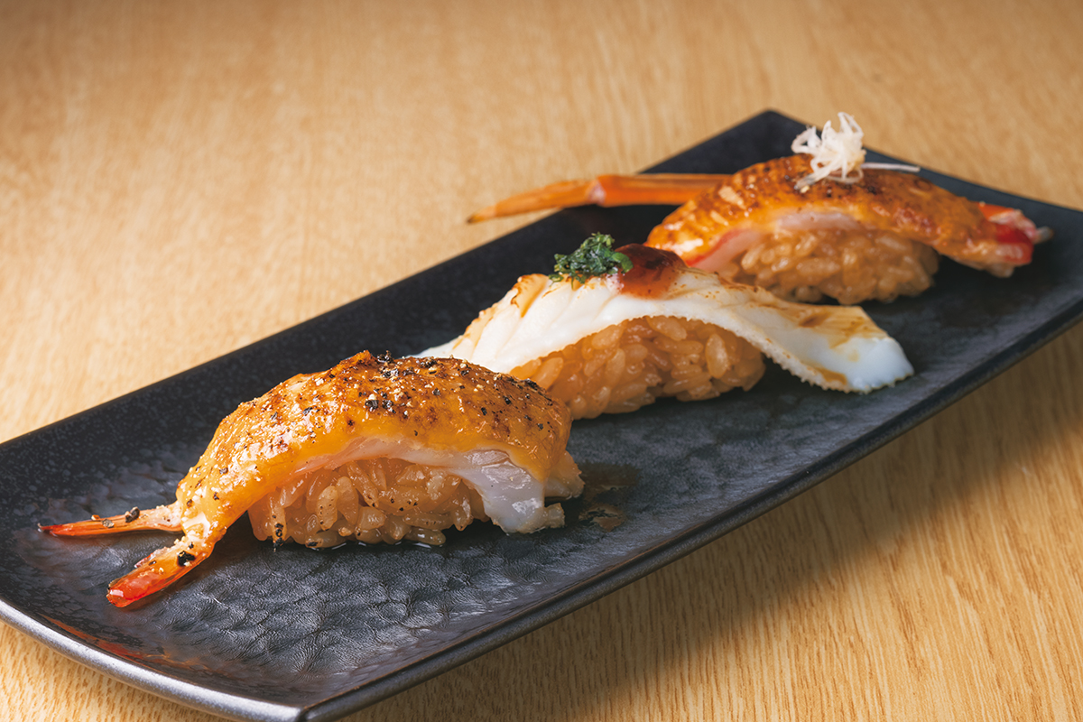 『九州寿司　寿司虎　Aburi　Sushi　TORA』Aburi　Premium　726円　左から炙りの生エビ、真イカ、ズワイガニ。Aburiはカナダ店から逆輸入の“第3の寿司”。秘伝のオリジナルソースを合わせたネタを炙った香ばしさと旨みが特筆もののおいしさ