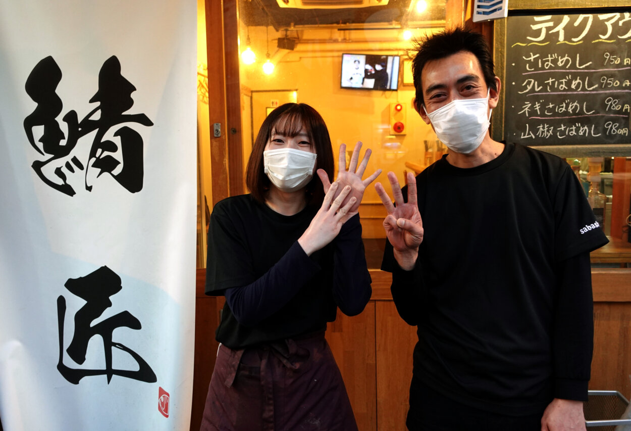 オーナーである泉谷勇二さん（右）と、スタッフの塩原陽花さん。ふたり揃って「『3』『8』（サバ）指」ポーズで