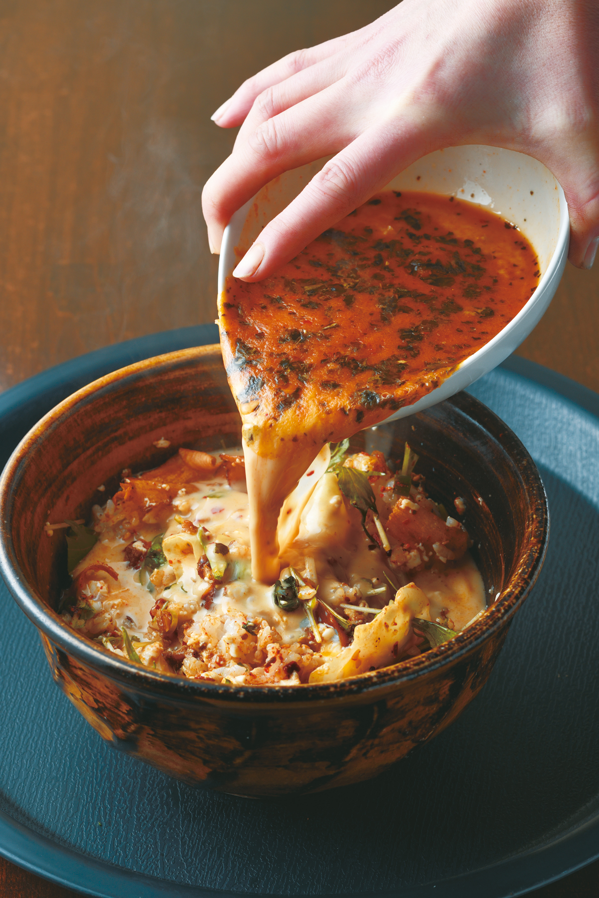 『スープカレー　ソウルストア』ご飯の上の具材（キャベツ、温玉、チーズ、梅風味の豆腐）を味わった後それらを混ぜ、さらにカレーをかけて雑炊風に