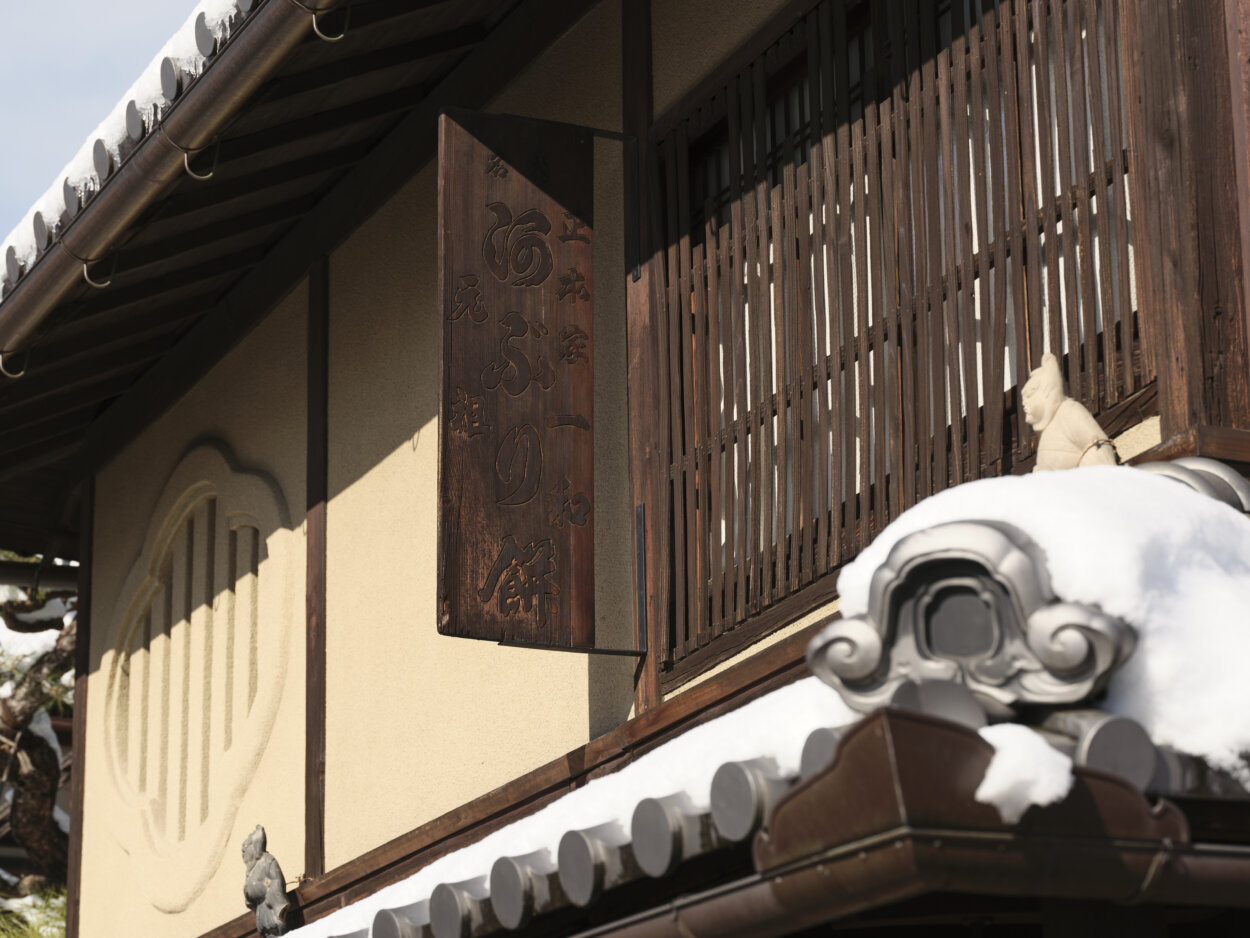 時を経たであろう木製の看板には「阿ぶり餅」の文字。店の建物は京都市の景観重要建造物に指定されている