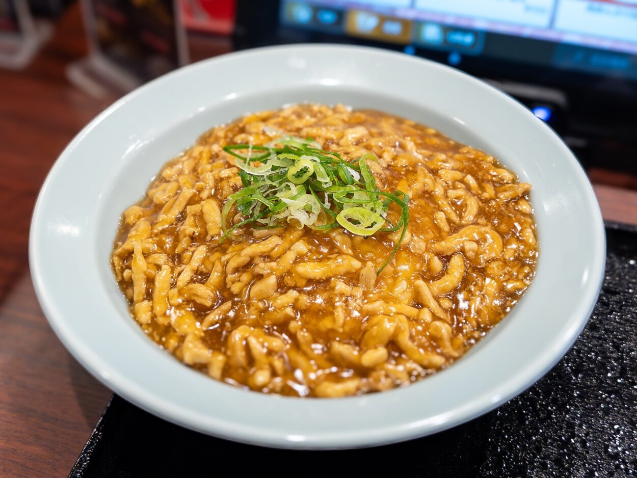 「肉あんかけチャーハン」。「温玉」（100円）や「野菜炒め」（200円）、「生ニンニク」（70円）などのトッピングも用意している