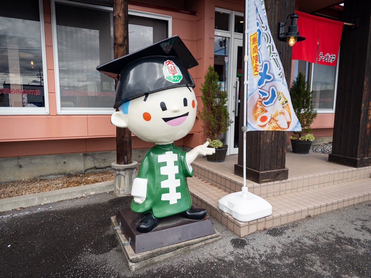 店の前で客を出迎える『ラーメン大学』のマスコットキャラクターの「大ちゃん」