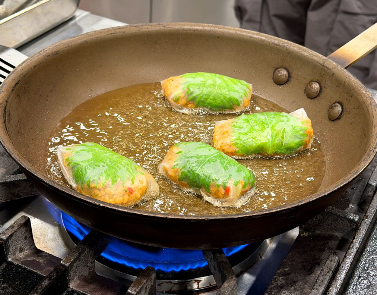 ライスペーパーに包まれ揚げ焼きされるおにぎり