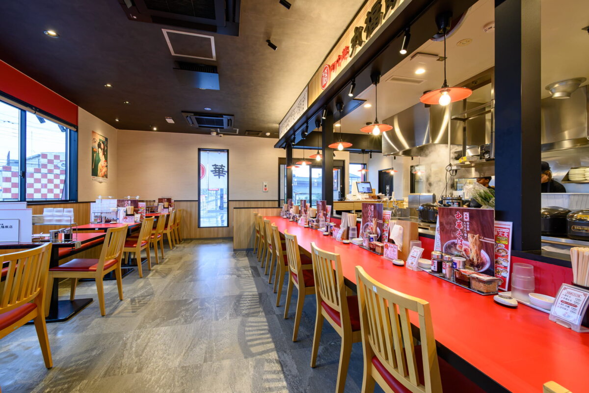 『町中華 丸福飯店』店内。赤を基調としたカウンターとテーブルが町中華っぽい